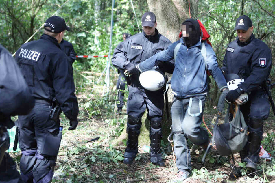 Zwei Polizisten führen einen Besetzer ab.