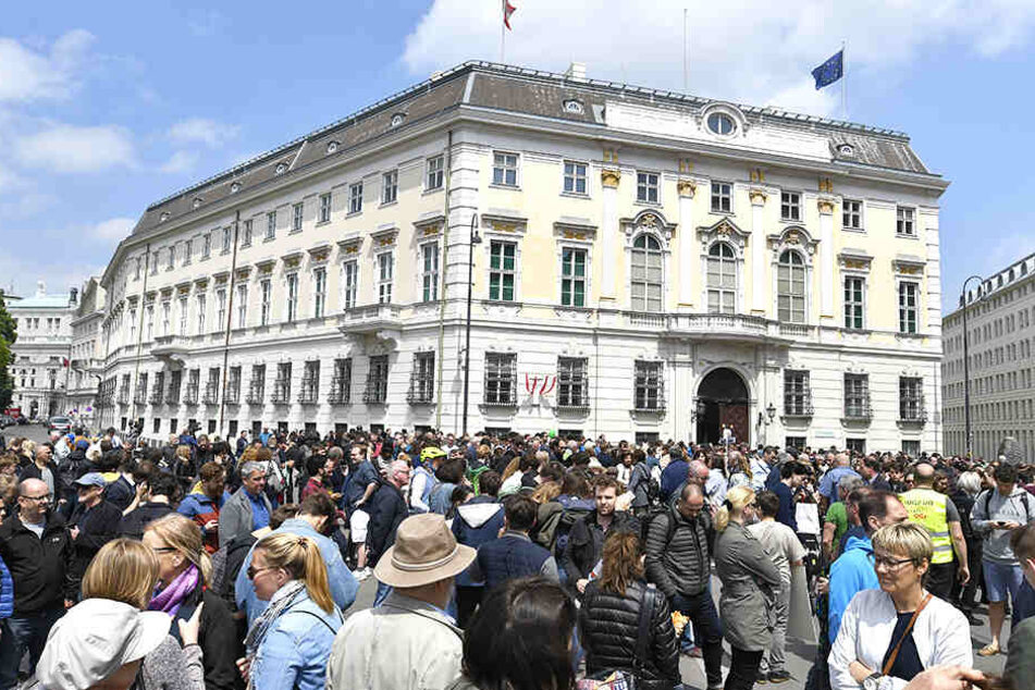 Menschen demonstrieren vor dem Bundeskanzleramt.
