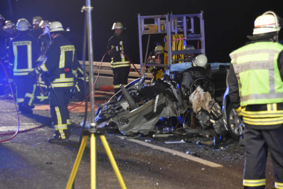 Feuerwehrleute neben dem verunfallten BMW.