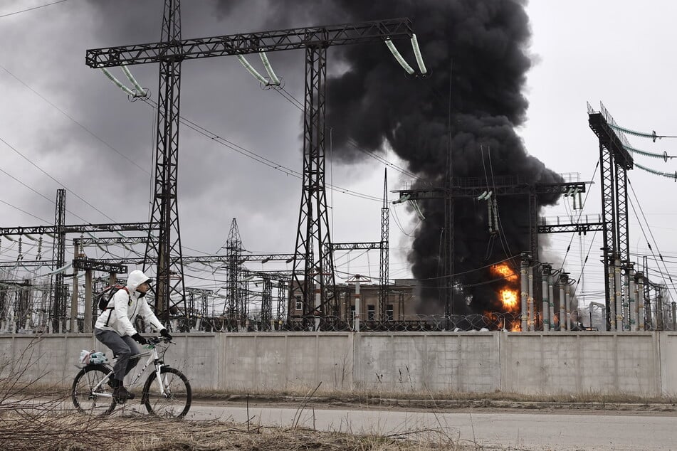 Ein Mann radelt nach einem russischen Angriff an einem Elektrizitätswerk vorbei. Durch heftige Luftangriffe zerstörte Russland jüngst Teile des Energiesystems der Ukraine.