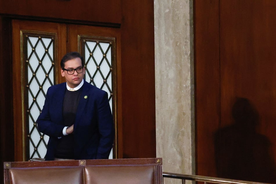 George Santos stands alone on the floor of the US House of Representatives.