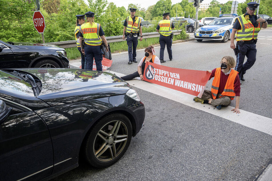 Aktivisten der Gruppe "Letzte Generation" blockieren das Ende einer Autobahnabfahrt bei München.