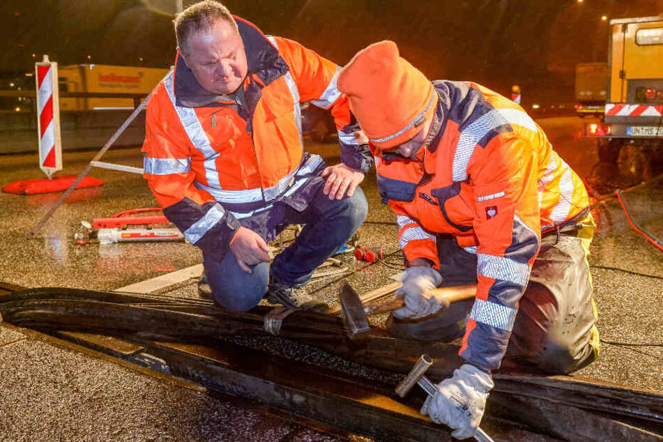 Zwei Baustellen-Mitarbeiter reparieren den Lamellen-Bruch auf der A7. (Archivbild)
