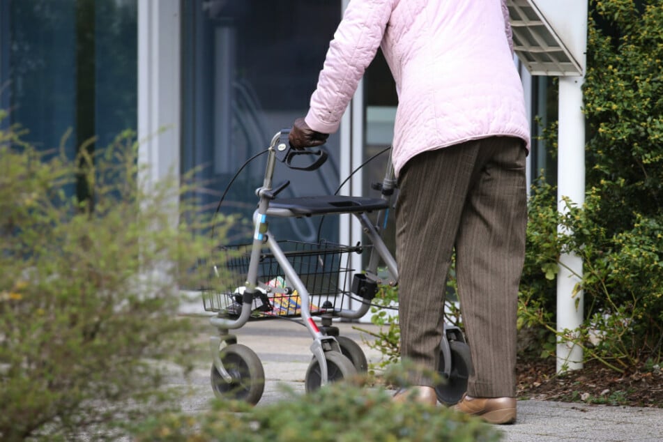 Eine ältere Frau geht mit ihrem Rollator.