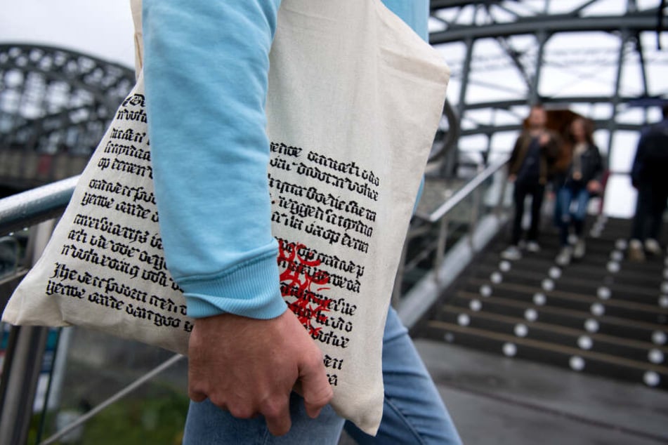 Ein Mann läuft mit einer Einkaufstüte des Münchner Buchhändlers Hugendubel eine Treppe rauf, auch international ist der Beutel ein Renner.