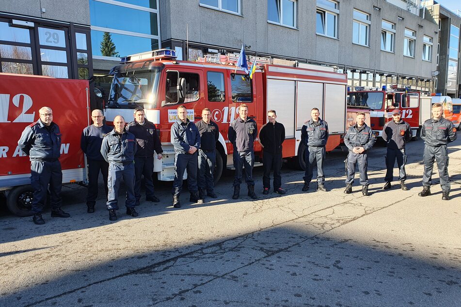 Mitglieder der Aachener Feuerwehr stehen vor zwei Löschfahrzeugen, die ebenso wie zwei Rettungswagen den Kollegen in der Ukraine geschenkt werden sollen.