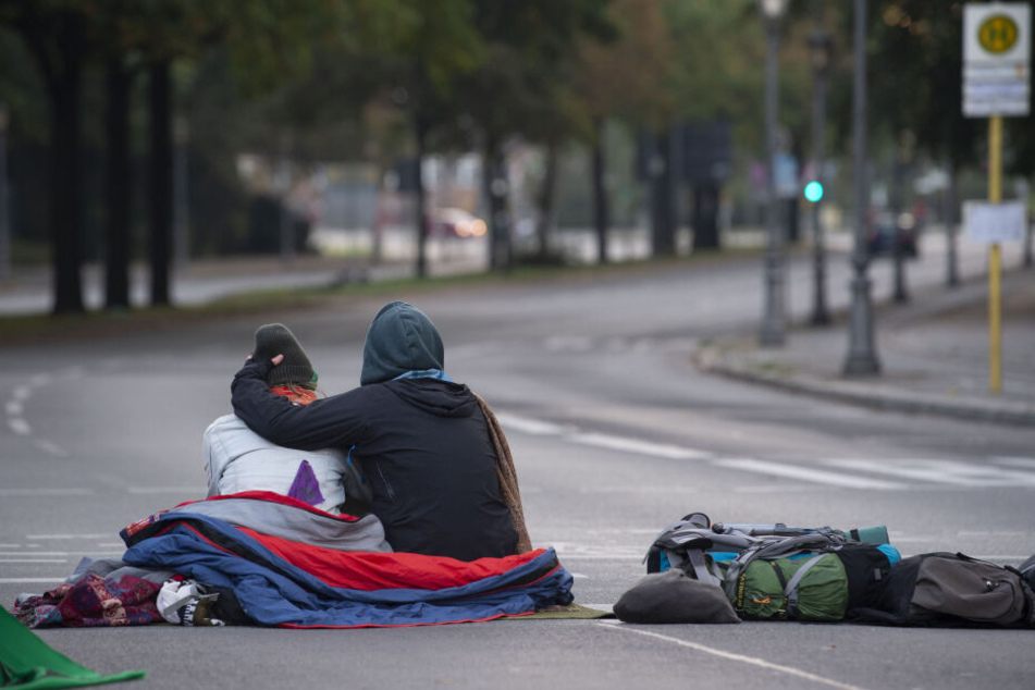Klima-Aktivisten haben die Zufahrten zum Großen Stern blockiert. Dieses Pärchen sitzt auf der Straße, die zum Schloß Bellevue führt.