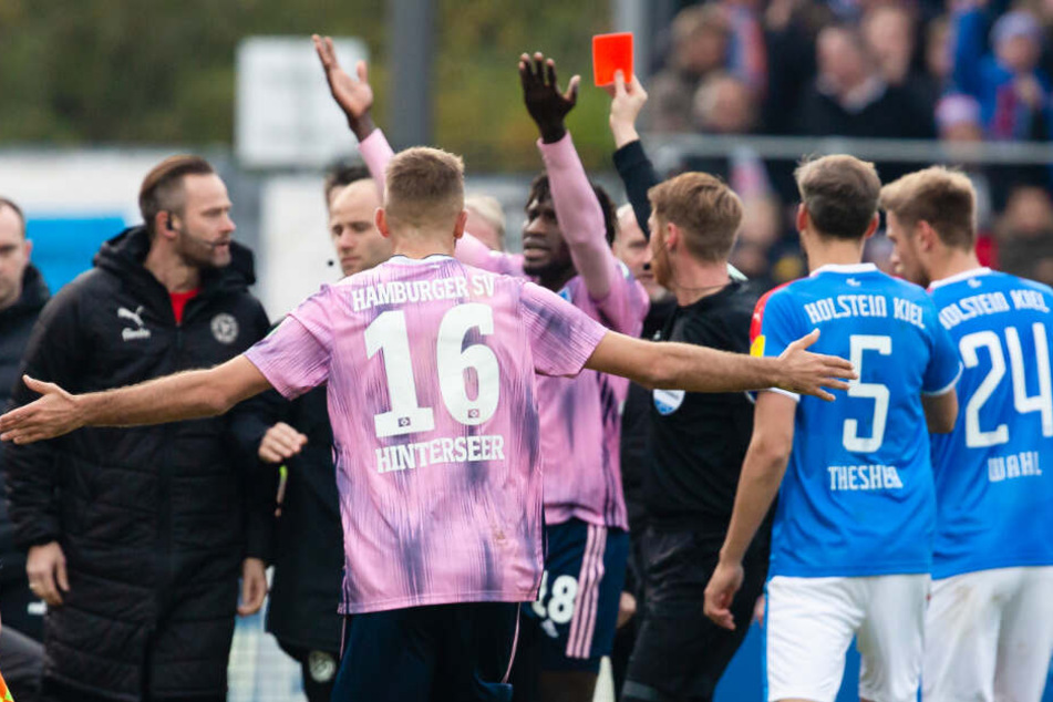 Schiedsrichter Christian Dingert zeigt Bakery Jatta die Rote Karte. Der HSV-Profi versteht hingegen die Welt nicht mehr