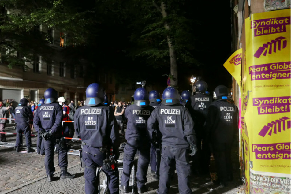 Polizisten filmen in der Nacht zum Freitag Menschen vor der Absperrung in der Weisestraße.