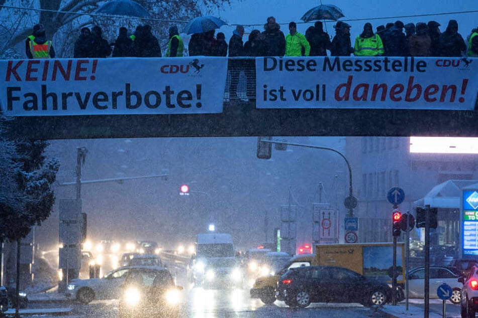 Demonstranten haben während einer Demonstration gegen das Dieselfahrverbot am Neckartor Plakate aufgehängt.