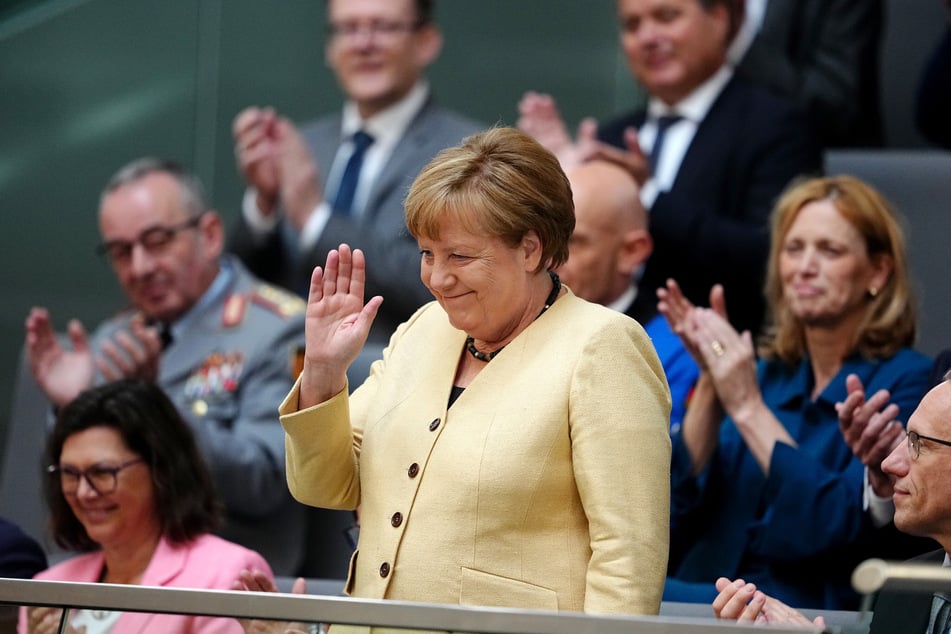 Angela Merkel (70, CDU), ehemalige Bundeskanzlerin, winkt vor der Kanzlerwahl im Bundestag auf der Tribüne.