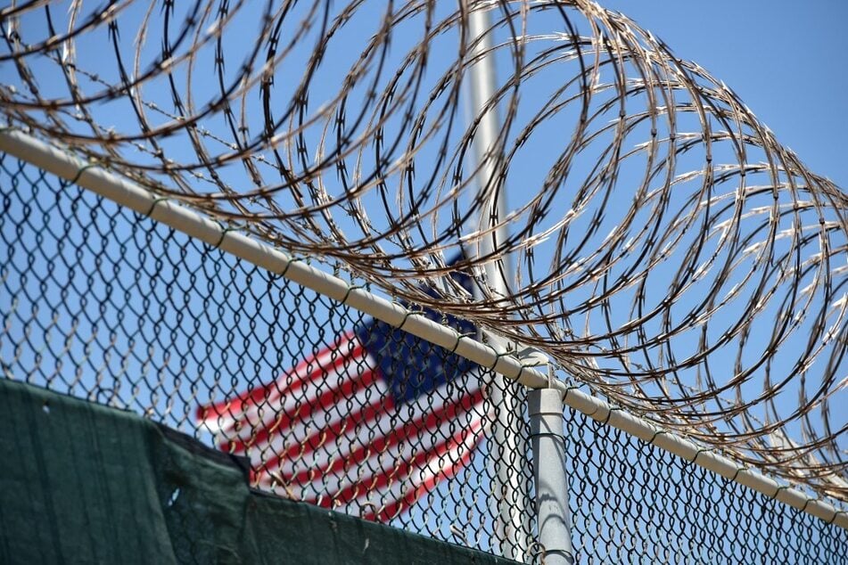 An American flag is pictured flying behind razor wire at the Guantanamo Bay detention facility in Cuba.