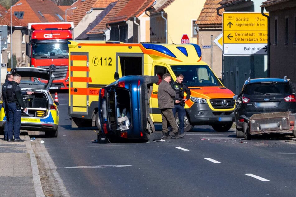 Ein VW krachte in einen parkenden Ford mit Anhänger und kippte zur Seite - der Fahrer wurde von den Rettungskräften behandelt.
