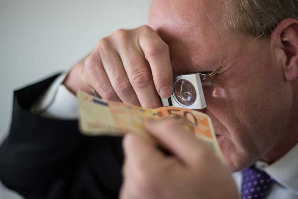 Ein Mitarbeiter des Analysezentrums der Deutschen Bundesbank prüft die Echtheit eines 50-Euro-Schein.