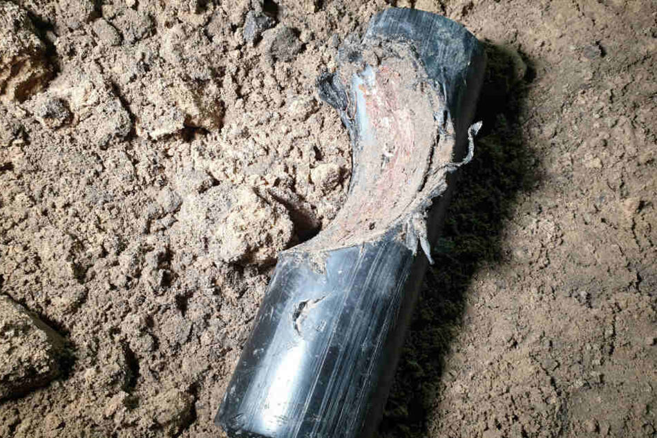 Ein beschädigtes Stück Stromkabel liegt in einer Baugruppe.
