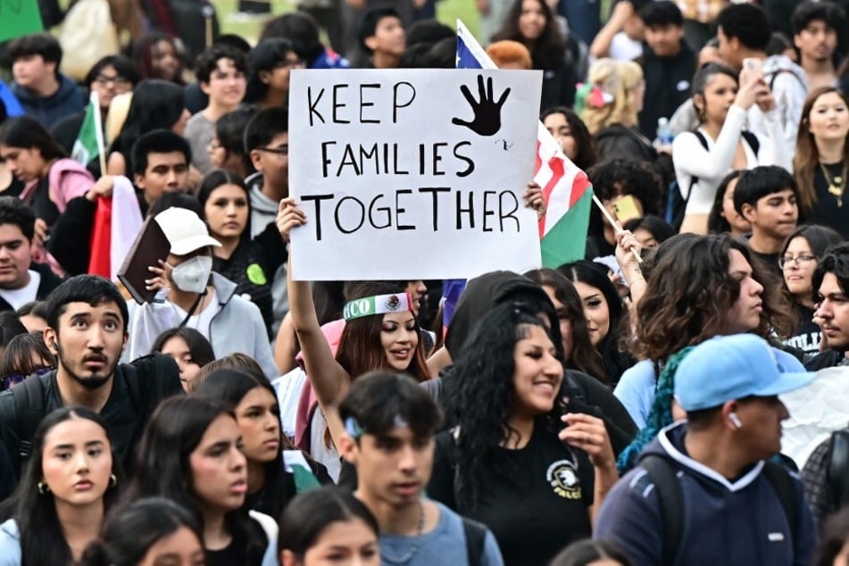 A person raises a sign reading "Keep Families Together" as hundreds of high-school students participate in a protest entitled "A Day Without Immigrants" in Los Angeles, California, on February 4, 2025