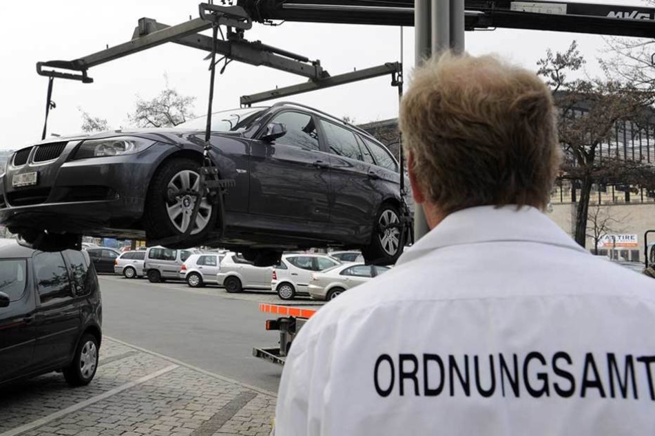 Ein Mitarbeiter des Ordnungsamtes lasst einen BMW abschleppen (Archivfoto).