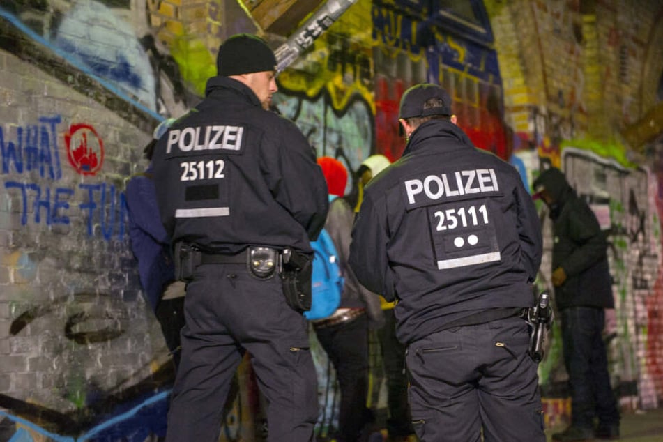 Polizisten stehen im Jahr 2014 bei einer Polizeiaktion im Görlitzer Park vor Personen, die kontrolliert werden sollen.
