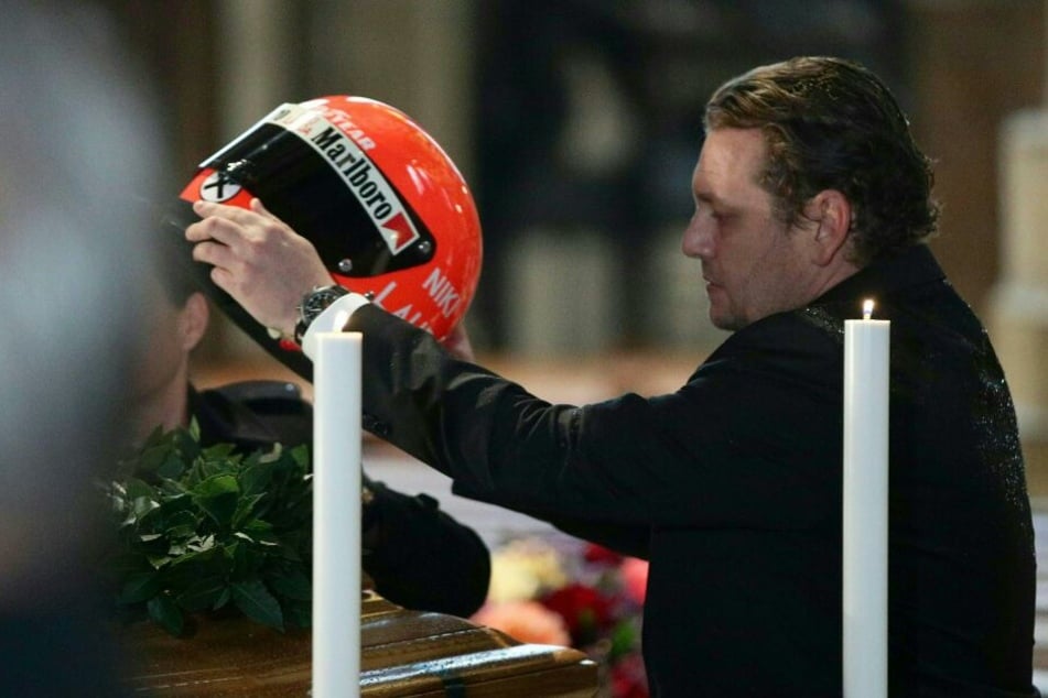 Niki Laudas Sohn Lukas legt den Helm auf den geschlossen aufgebahrten Sarg seines Vaters.