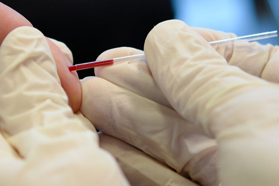 Keine Menge, große Sicherheit: Ein Arzt nimmt an dem Finger eines jungen Mannes Blut ab. (Archiv)