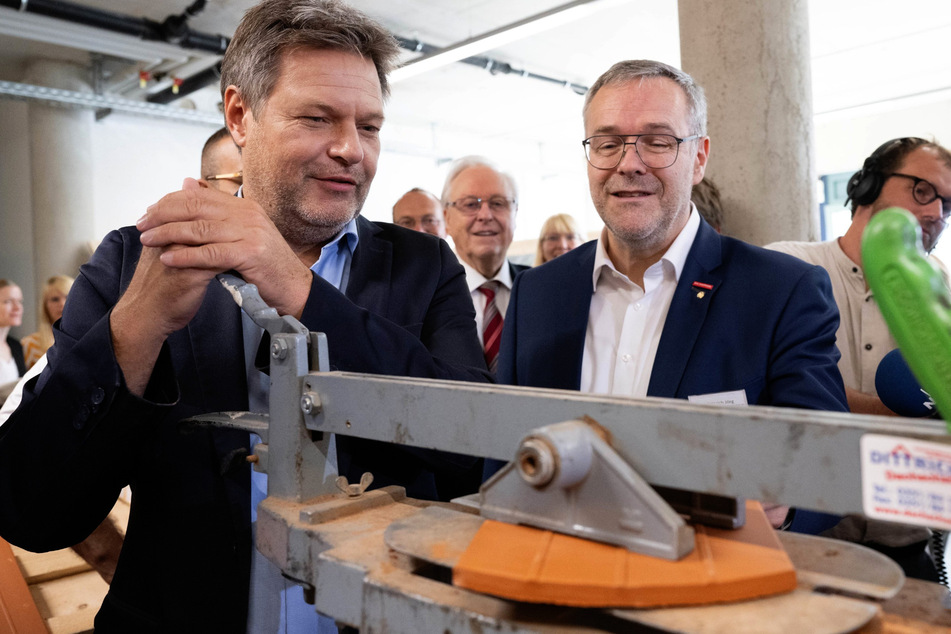 Bundeswirtschaftsminister Robert Habeck (53, Grüne) versuchte sich im Dachdeckerbetrieb von Handwerkspräsident Jörg Dittrich (53, r.) am Zuschneiden von Dachziegeln.
