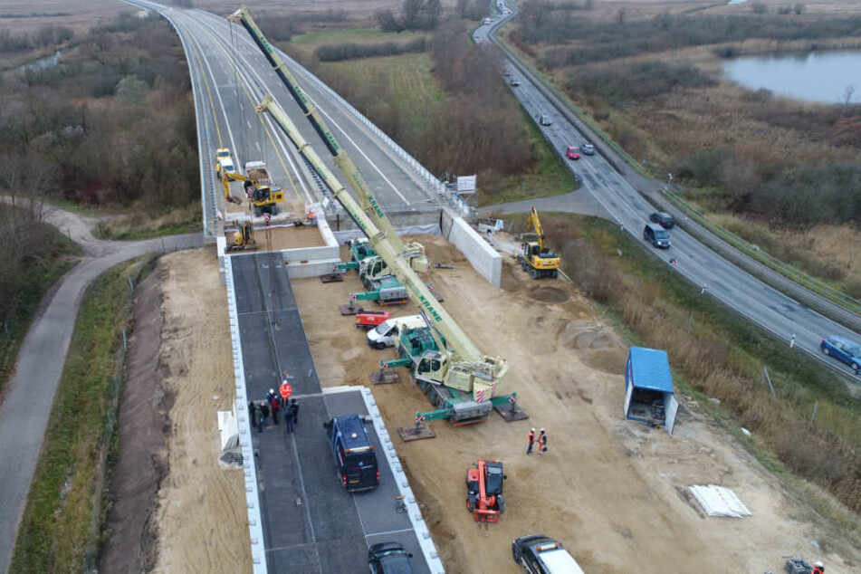 An der Behelfsbrücke für die abgesackte Autobahn A20 wird das letzte Bauteil verlegt.