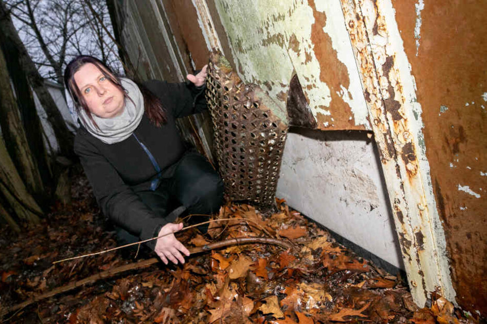 Marlen Gläßer (40) zeigt an der Rückseite der Lagerhalle die jetzt wieder verschlossene Öffnung, durch welche die Diebe den Motor klauten.