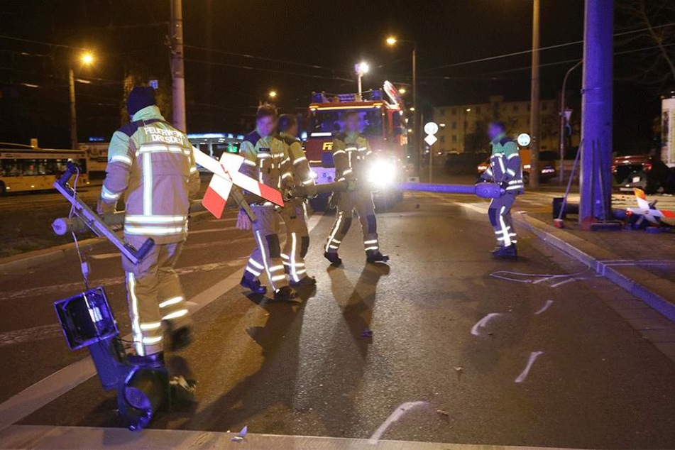 Feuerwehrmänner transportieren den gefällten Ampelmast ab.