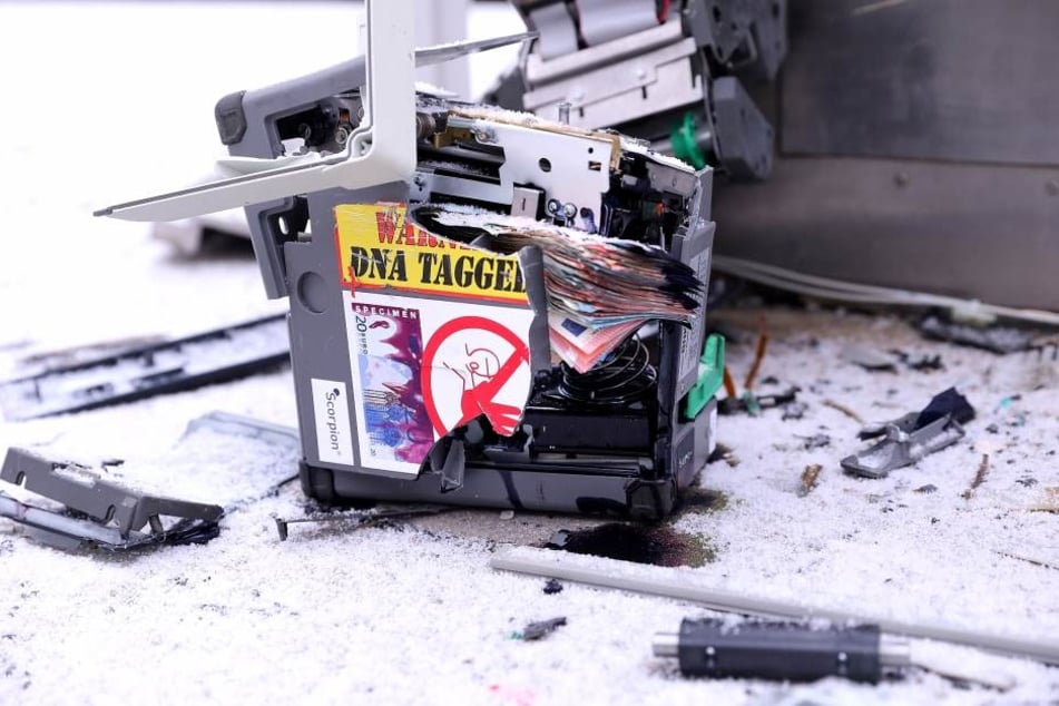 Ob die Täter überhaupt Erfolg hatten, ist unklar. Denn aus der herausgeschleuderten Kassette ragen zahlreiche Geldscheine.
