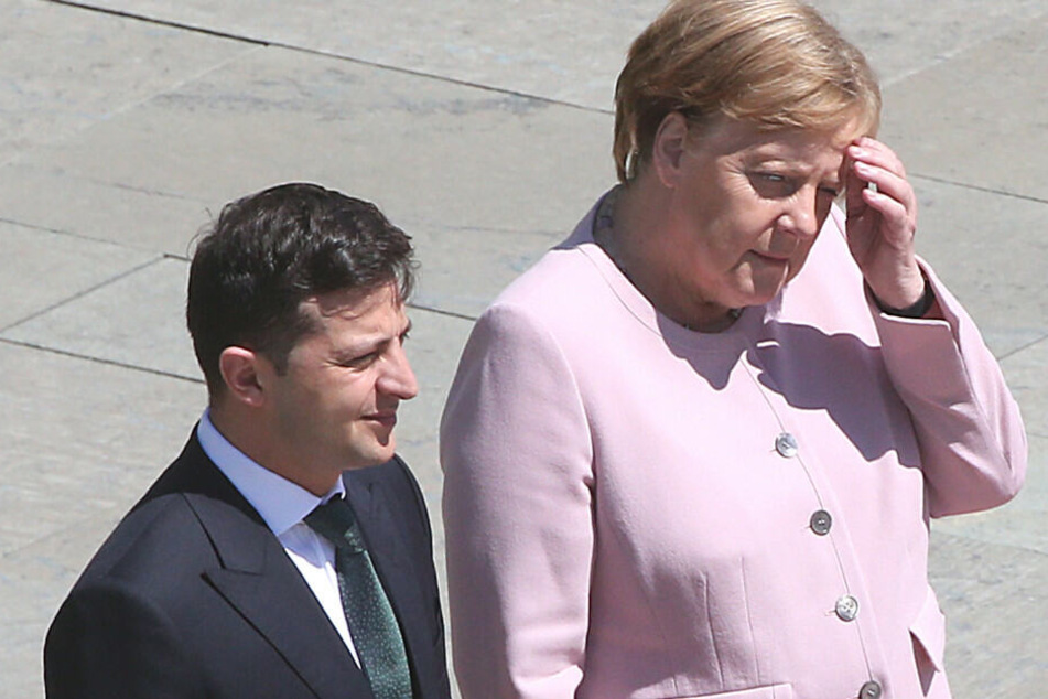 Merkel und Selensky verfolgen die Nationalhymne.