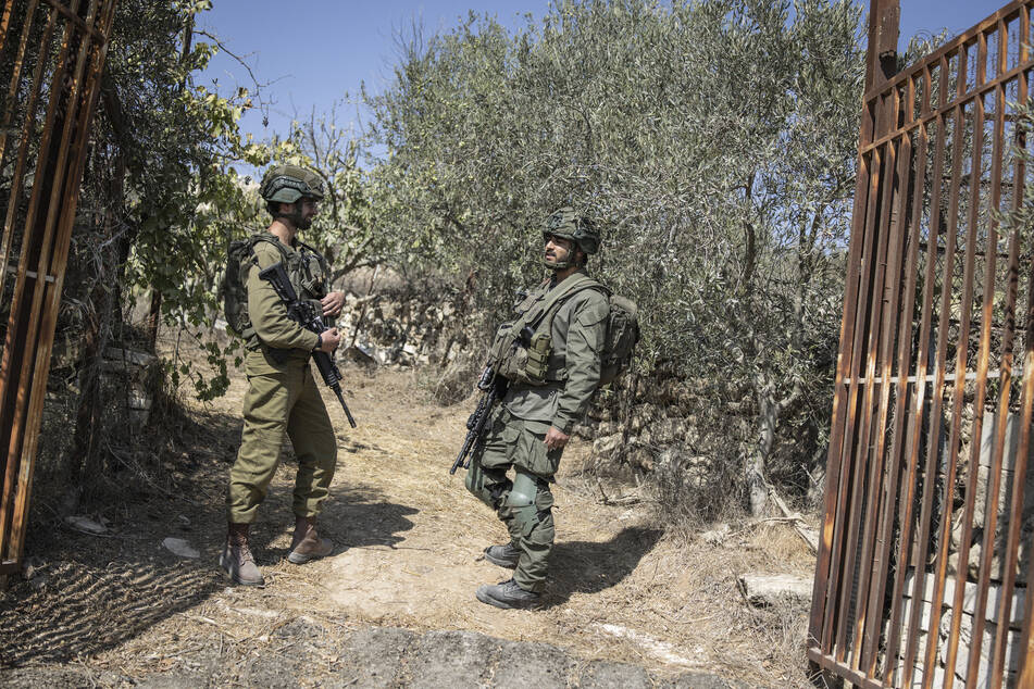 Israeli soldiers block the entrance to a Palestinian olive field near the Israeli settlement of Elazar south of Bethlehem in the occupied West Bank on October 17, 2025.