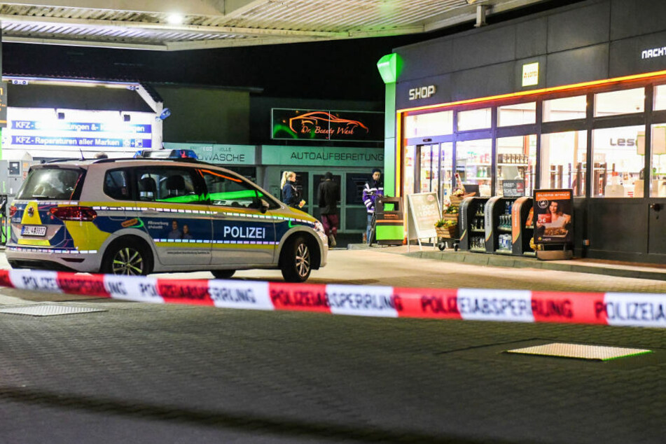 Ein Polizeiwagen steht hinter Flatterband vor einer Tankstelle in Brandenburg. (Symbolbild)