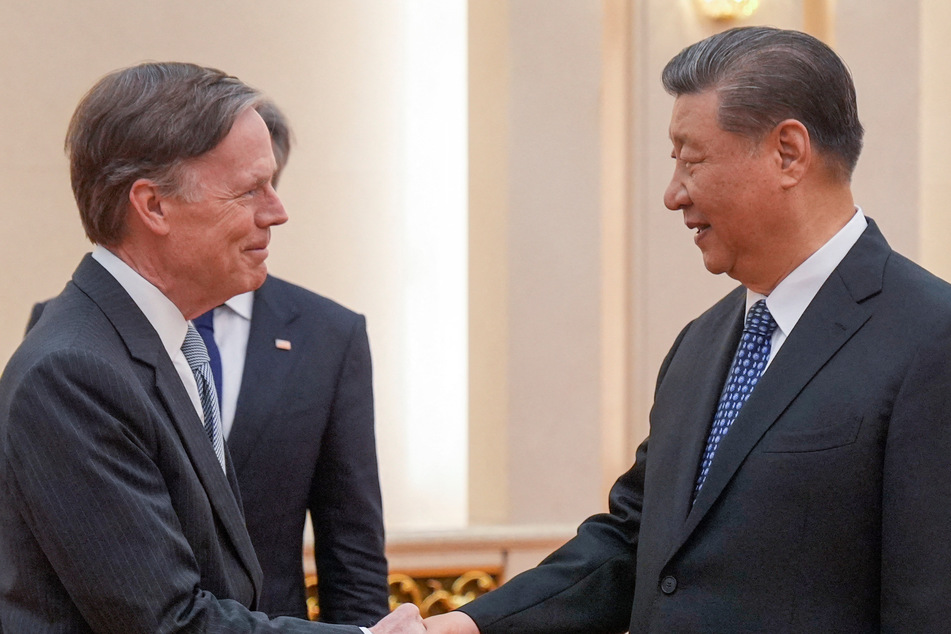 US Ambassador to China Nicholas Burns (l.) shakes hands with China's President Xi Jinping on April 26, 2024.