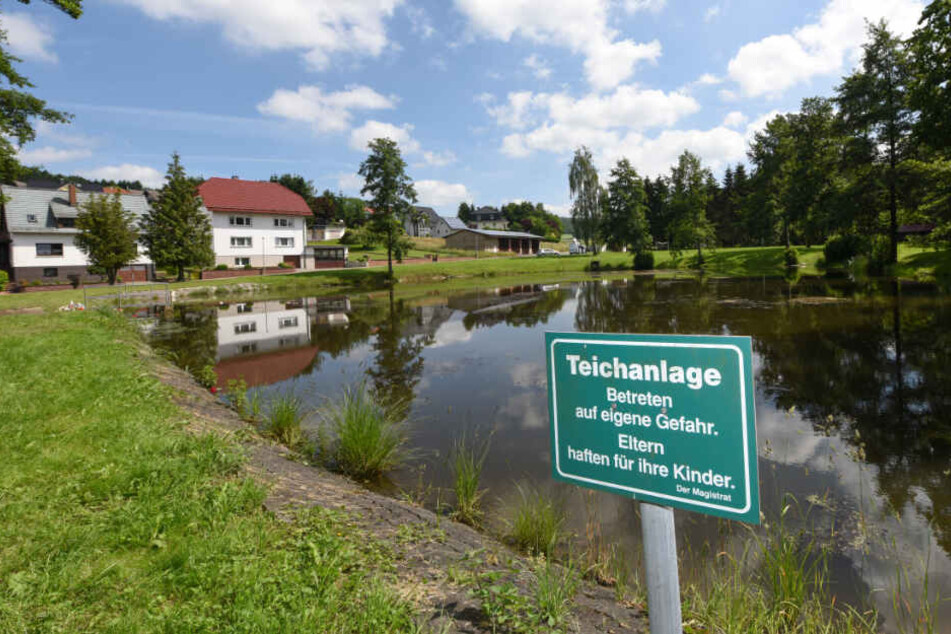 Ein Schild mit der Aufschrift "Teichanlage - Betreten auf eigene Gefahr. Eltern haften für ihre Kinder." steht an einem Teich im Ortsteil Seigertshausen.