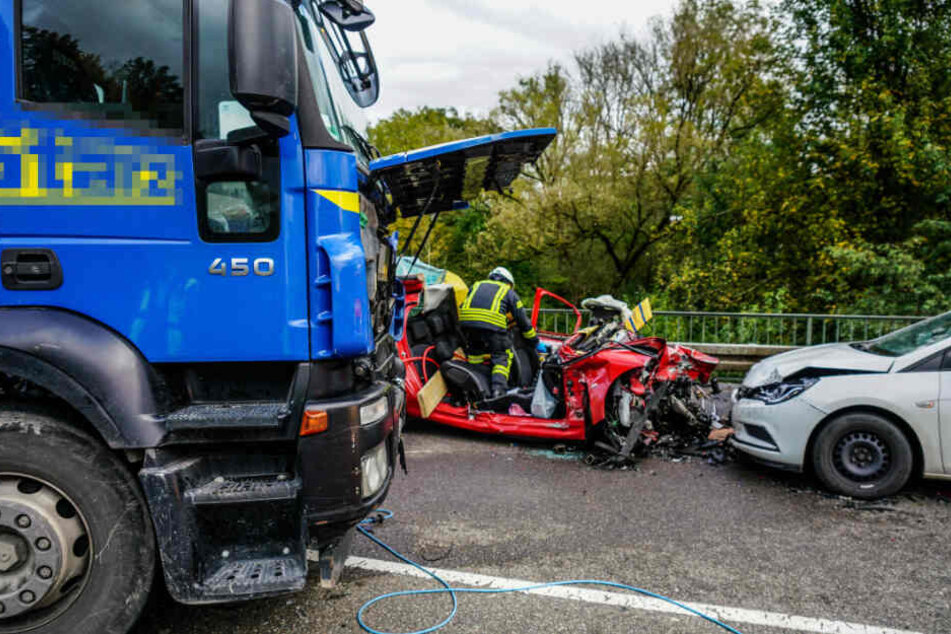 Ein Feuerwehrmann geht an der Unfallstelle seiner Arbeit nach.