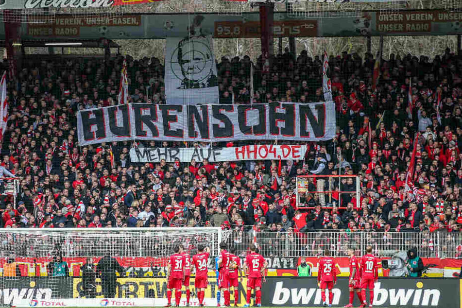 Union-Fans halten ein Banner mit Dietmar Hopp im Fadenkreuz in die Höhe.