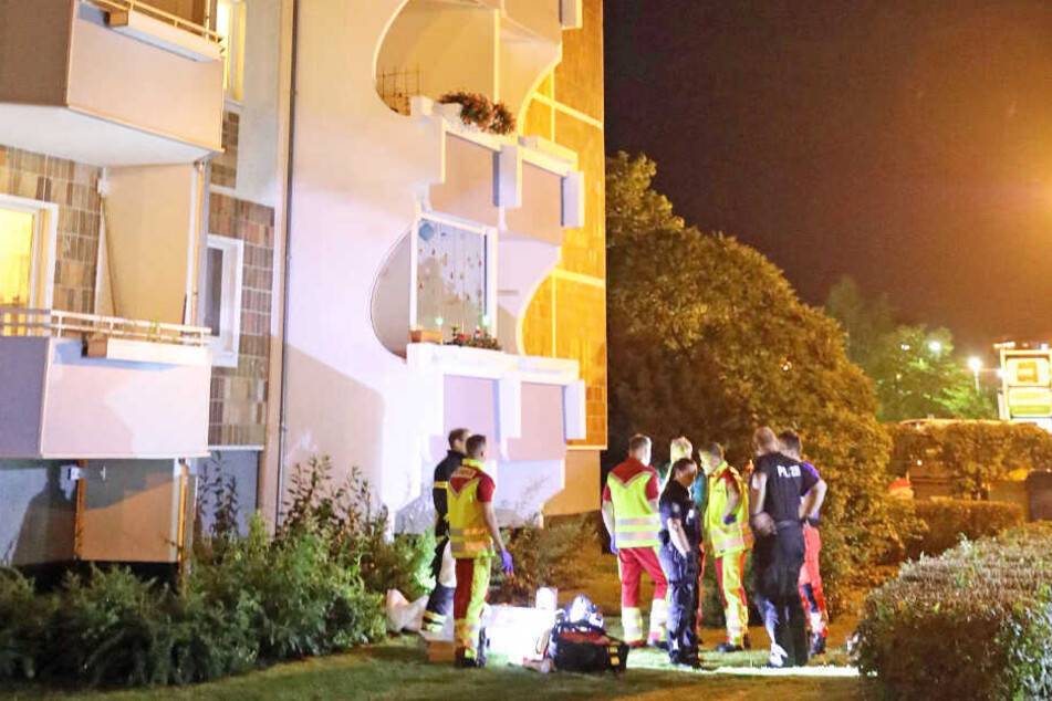 Polizei und Rettungsdienste stehen vor dem Plattenbau.