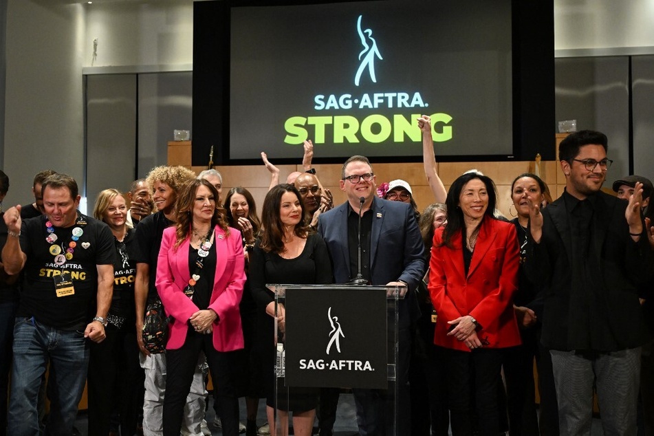 Duncan Crabtree-Ireland speaks, flanked by SAG-AFTRA President Fran Drescher and union members, during a press conference following the end of the strike in Los Angeles, California, on November 10, 2023.