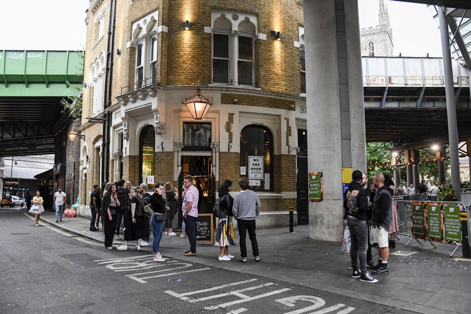 London: Die Menschen stehen und trinken vor einem Pub am Borough Market. Aufgrund der sich zuspitzenden Corona-Krise in Großbritannien hat Premierminister Johnson verschärfte Schutzvorkehrungen angekündigt.