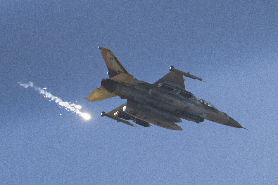 Leuchtraketen fliegen aus einem israelischen Kampfflugzeug beim Überflug über den Gazastreifen.