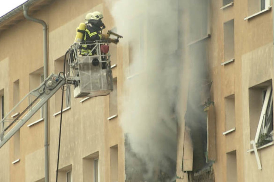 Zwei Feuerwehrkameraden stehen im Oktober auf einer Drehleiter und löschen die brennende Wohnung. Der Mieter Denis S. (29) soll sie selbst angezündet haben.