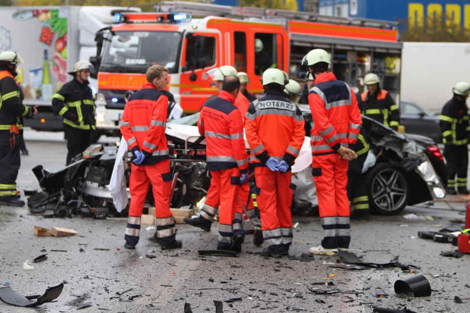 Einsatzkräfte stehen vor dem Unfallfahrzeug am Kaltenkircher Platz.