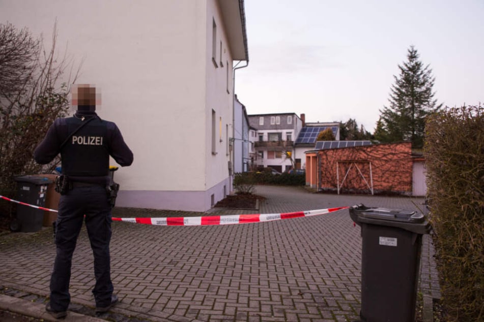 Ein Polizist steht vor einem Absperrband.