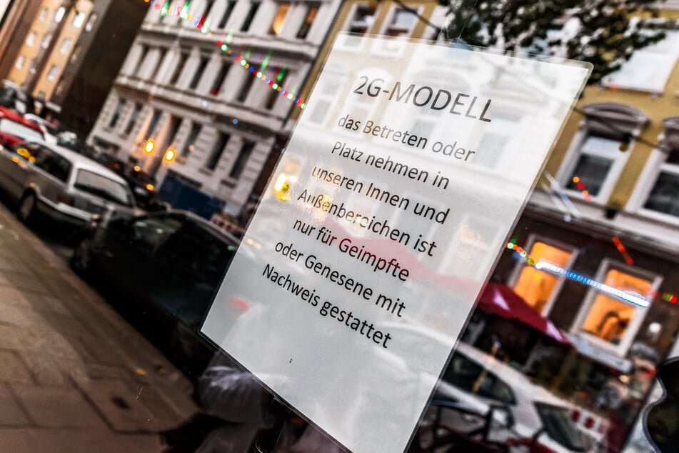 Im Fenster einer Kiez-Kneipe hängt ein Zettel zum 2G-Modell.