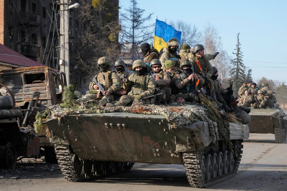 Ukrainische Soldaten fahren auf einem Panzer von Typ APC auf einer Straßen der Stadt Trostianets. Die russische Seite warf ukrainischen Truppen erneut vor, aus den umkämpften Städten Sumy und Saporischschja fliehende Zivilisten beschossen zu haben.