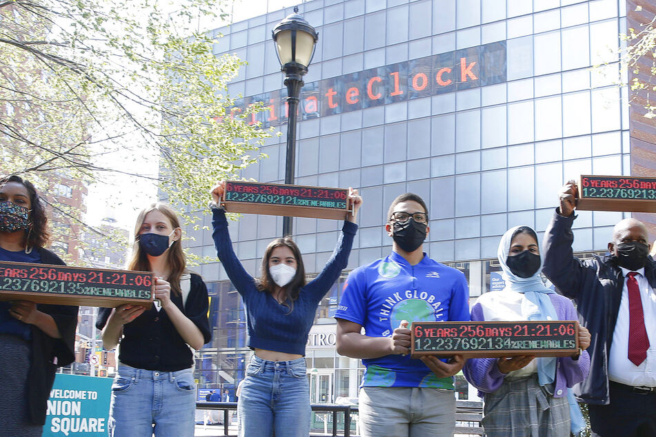 Protesters demand faster climate action under New York Climate Clock in April 2021.