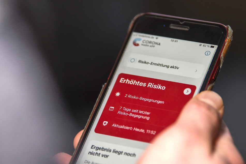 Auf einem Handy zeigt die Corona-Warn-App ein erhöhtes Risiko an, welches darauf hinweist, Kontakt mit infizierten Personen gehabt zu haben.