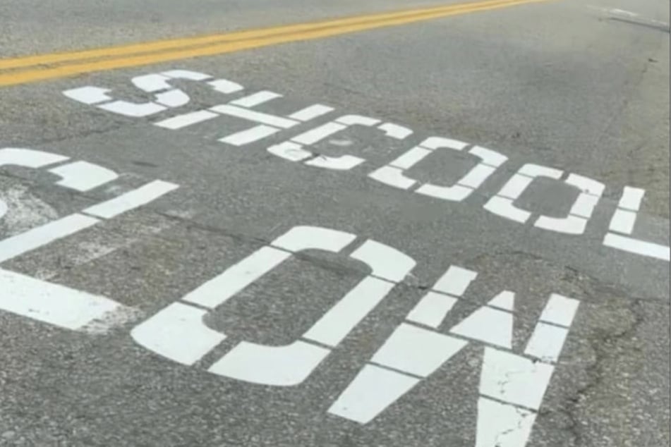 Die Straßenmarkierung "Shcool Slow" soll Autofahrer darauf aufmerksam machen, langsam zu fahren. Aber weswegen?
