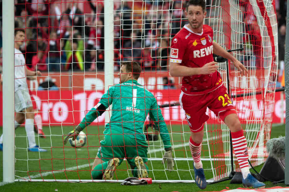 Kölns Mark Uth (r) bejubelt sein Tor zum 1:4 und Bayerns Torwart Manuel Neuer kniet im Tor.