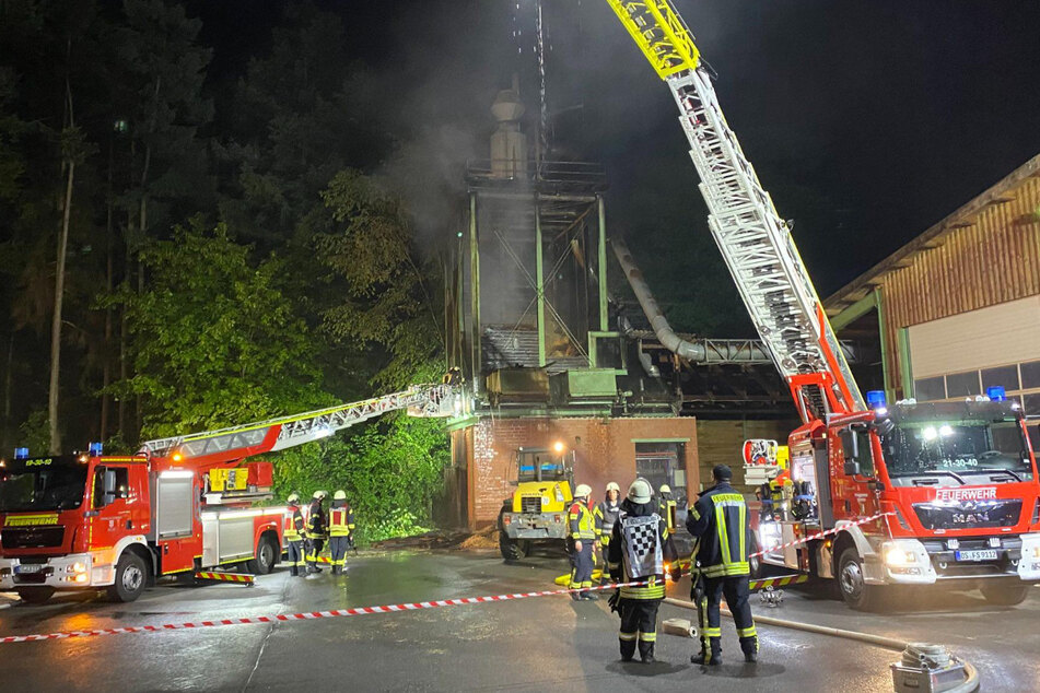 Einsatzkräfte der Feuerwehr löschen den Brand in einem Sägewerk.